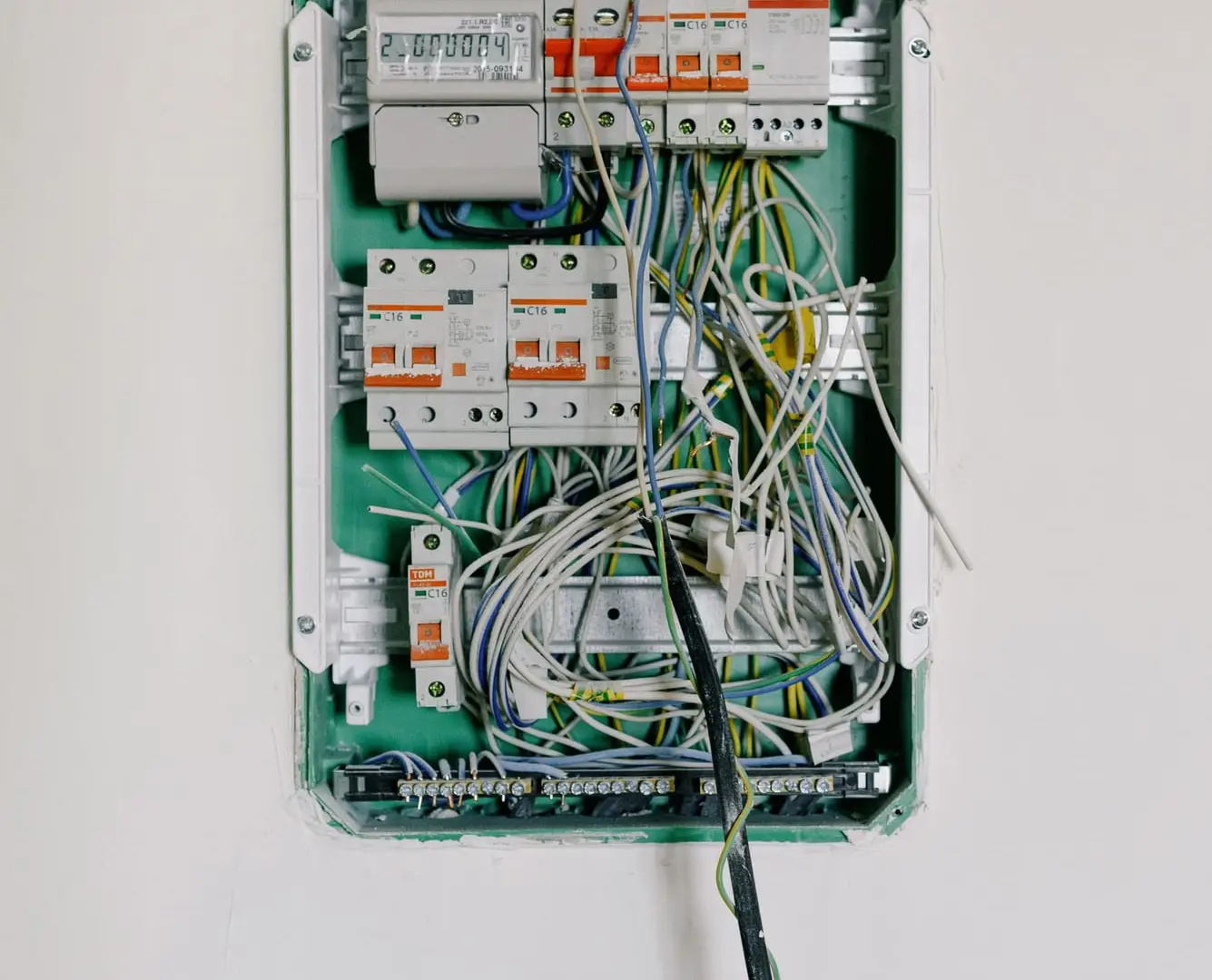 Open consumer unit on a white wall, ready for its new RCBOs