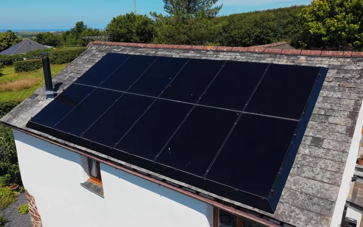 All-black solar panels on the slate roof of a white Cornish cottage