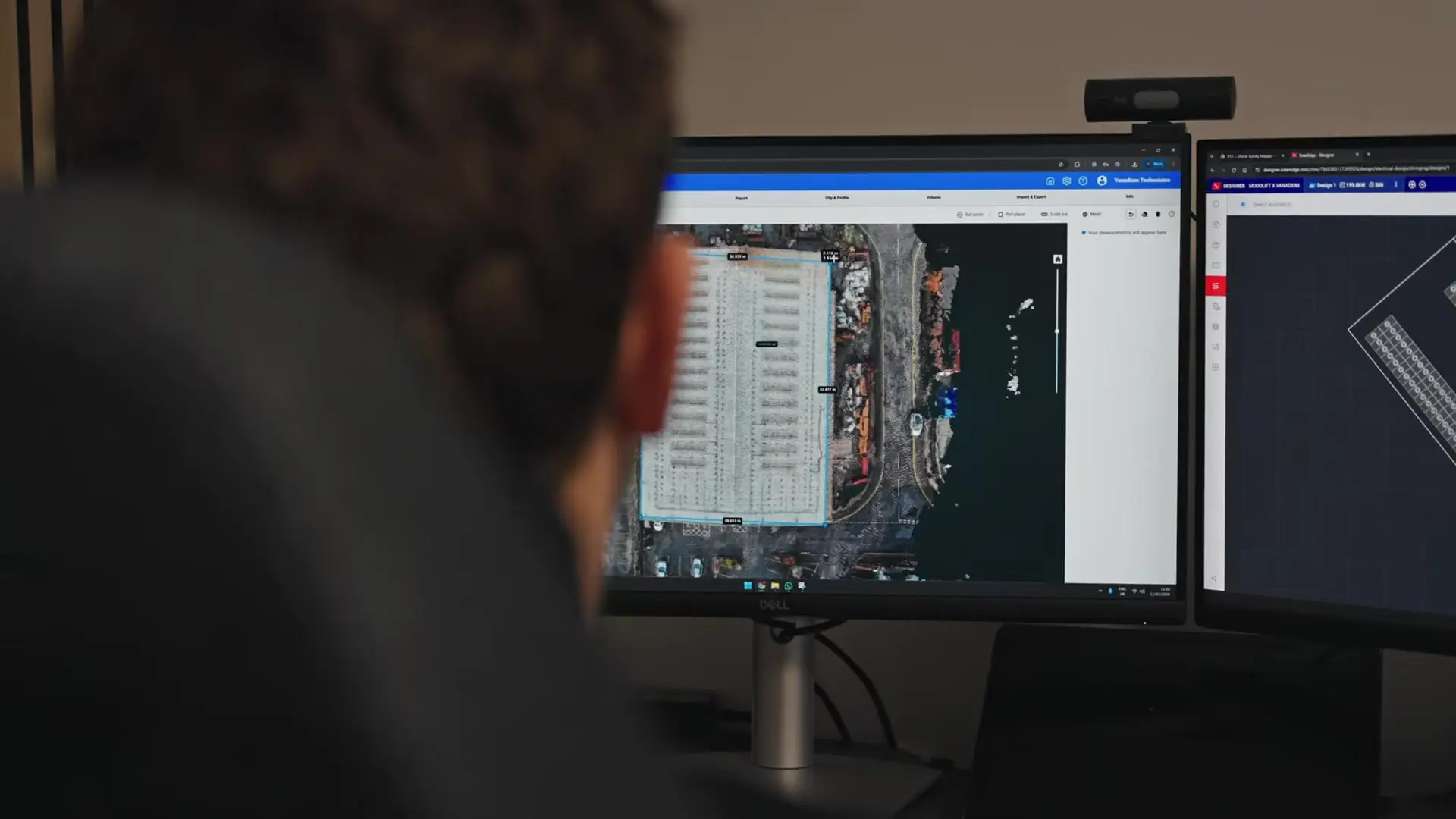 Vanadium designer laying out a commercial solar array over the drone survey on two screens