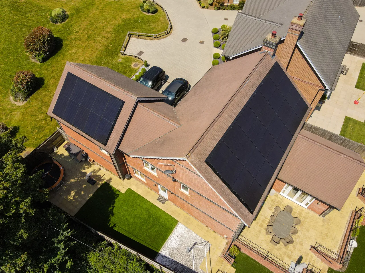 Drone photograph looking down on a tiled roof with solar panels being laid out