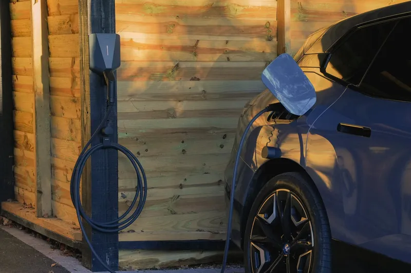 Easee home charger on a timber garage, car charging
