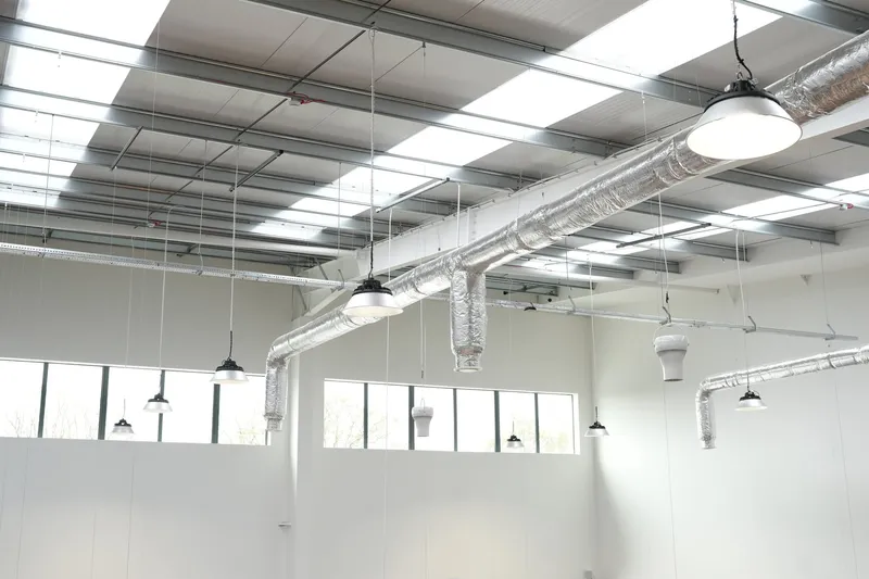 High-bay lighting and insulated services across the workshop ceiling