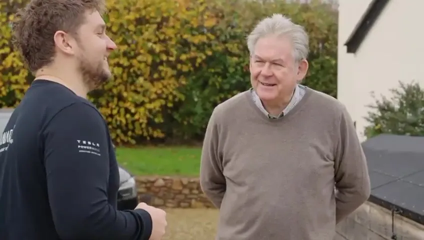 A Vanadium installer holding a mug and smiling while talking to the homeowner.