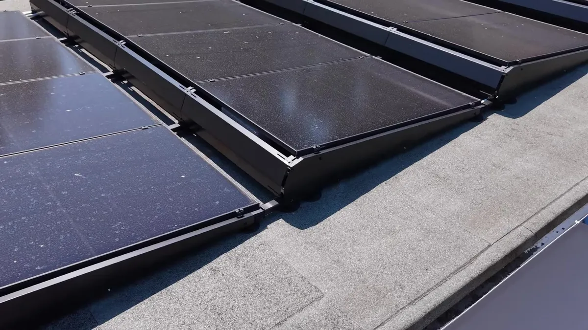 Solar panels installed on a flat roof, showing dust accumulation.