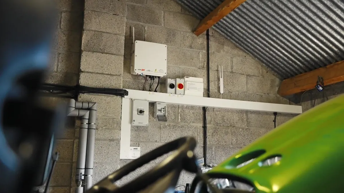 Solar inverter and electrical equipment installed on a block wall in a garage.