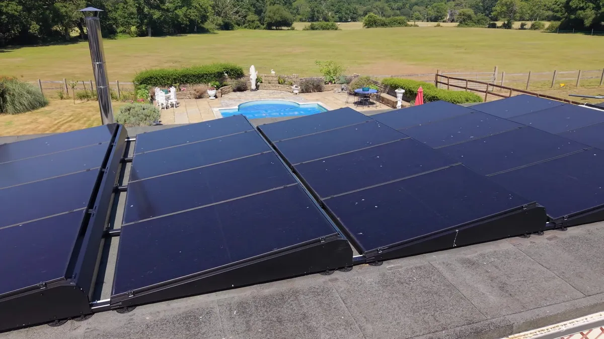 Close-up of black solar panels on a flat roof, showing the mounting system.