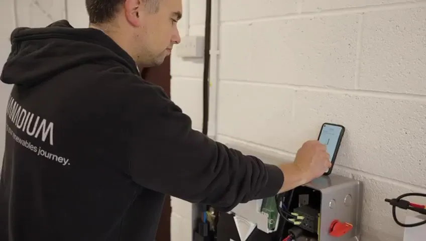 A Vanadium installer using a smartphone to configure or monitor the solar and battery system.